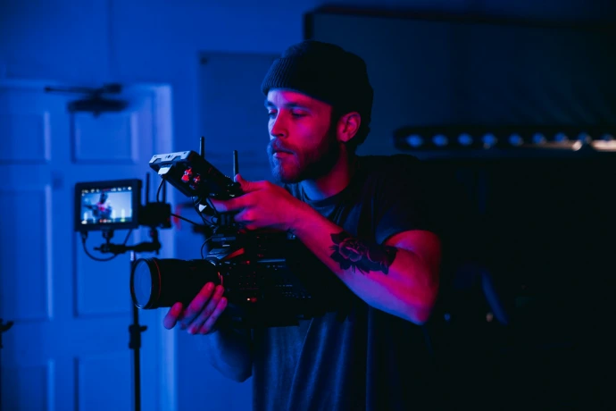 man in black t-shirt holding video camera